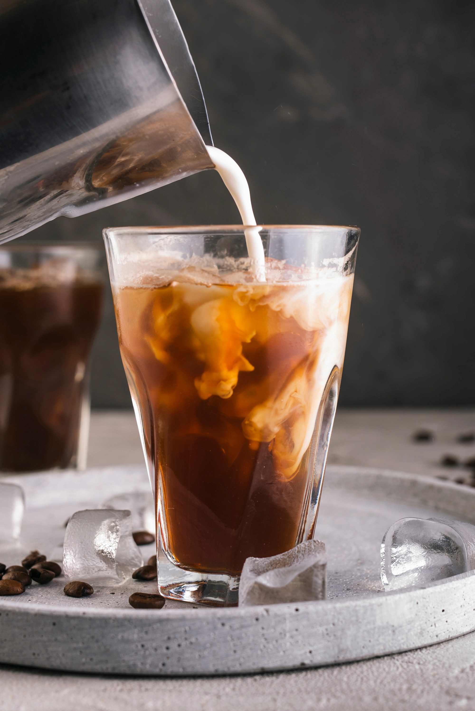 Milk swirling into iced coffee