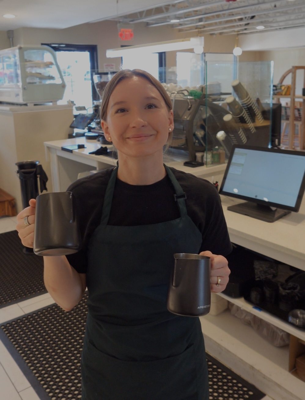 Cube Coffee barista holding steaming pitchers